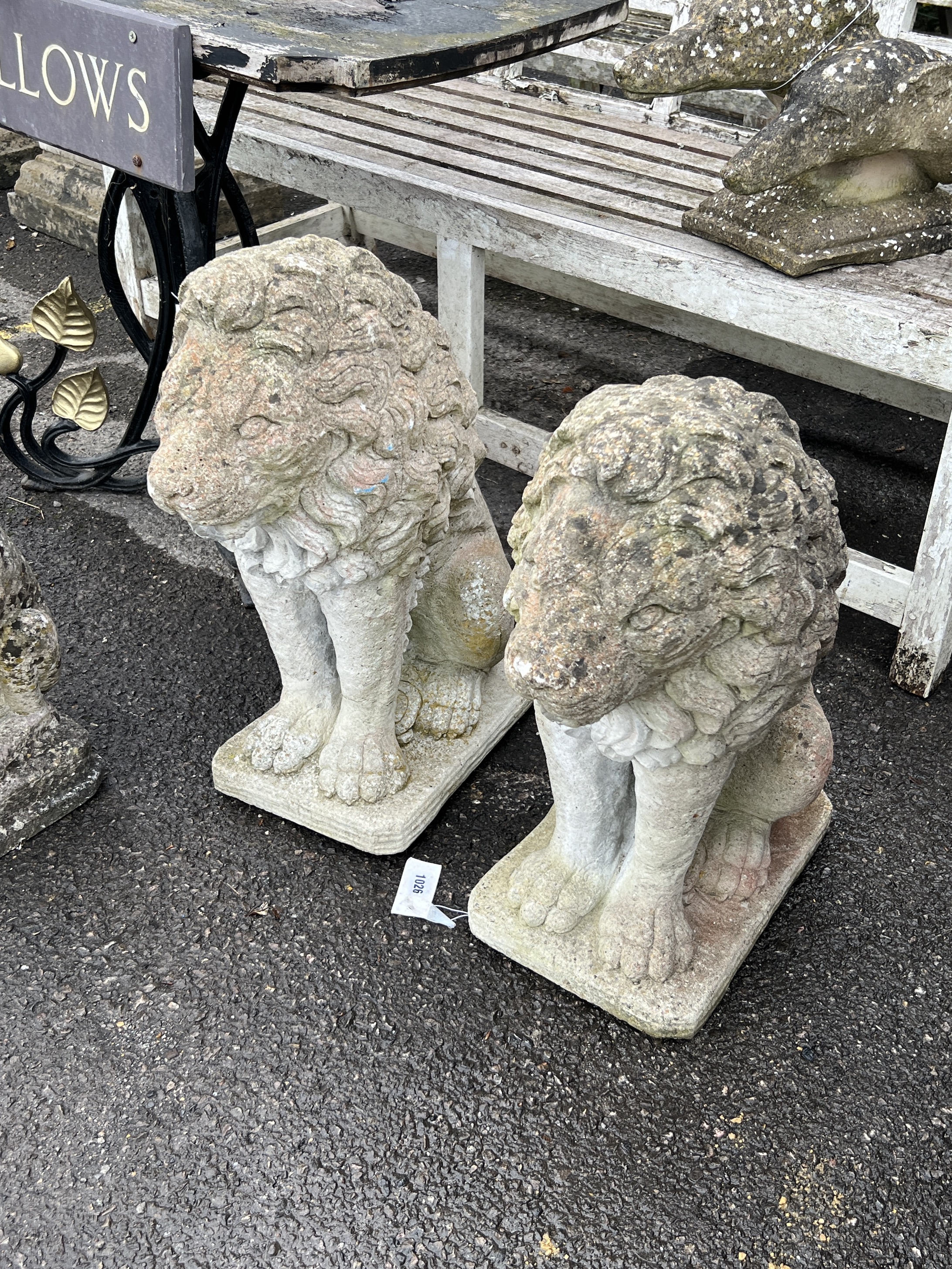 A pair of reconstituted stone seated lion garden ornaments, height 62cm